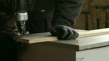 a man with a jigsaw sawing wood in a workshop 