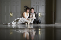 bride and groom sitting on a marble floor