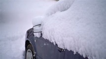 Snow snowing over car parked in snowy street background in cold winter season
