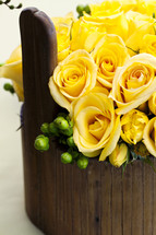 Flower arrangement yellow roses in wood vase basket