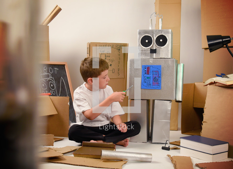 a boy building a cardboard robot 