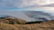 Epic misty clouds moving over alpine mountains in autumn nature landscape Time-lapse
