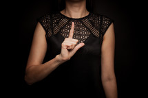 a woman holding an L over her chest 