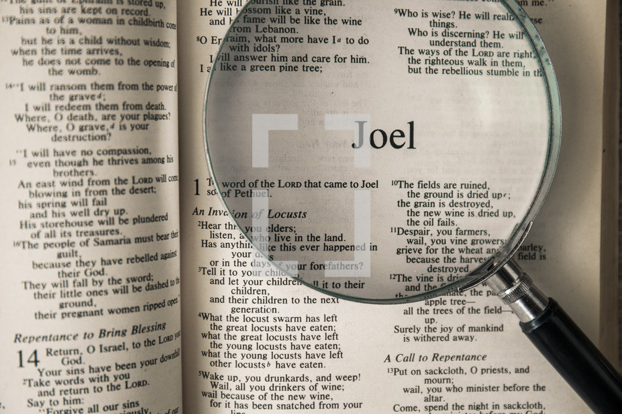 magnifying glass over Bible - Joel 