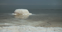 Close up of salt deposits on the banks of the Dead Sea in Israel. The Dead Sea and the Jordanian mountains in the background