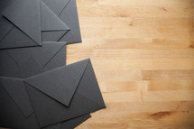 black envelopes on a wood floor 