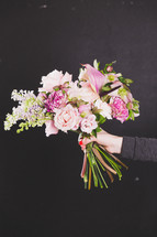 a woman holding out a bouquet of flowers 