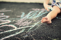toddler playing with sidewalk chalk 