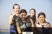 kids on a boat in life vests 