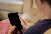 a woman sitting on a couch with a tablet 