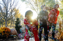 children playing with bubbles in fall 