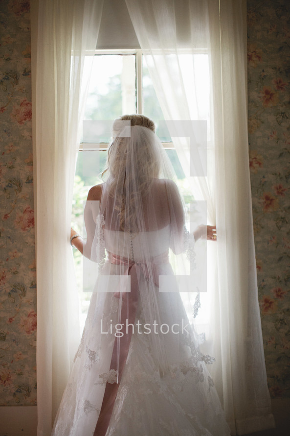 Bride looking out window