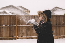 a girl blowing snow outdoors in winter 
