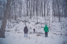 people walking through a forest in the winter 