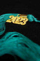 a 2023 graduation tassel on black