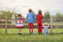family in patriotic colors looking over a fence 