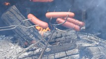 roasting hotdogs over a fire 