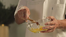 Close-up of man mixing eggs in bowl.