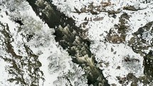 Drone footage of a river in snow covered Colorado Rocky Mountains. 