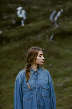 a woman standing on a mountainside in Norway with closed eyes 