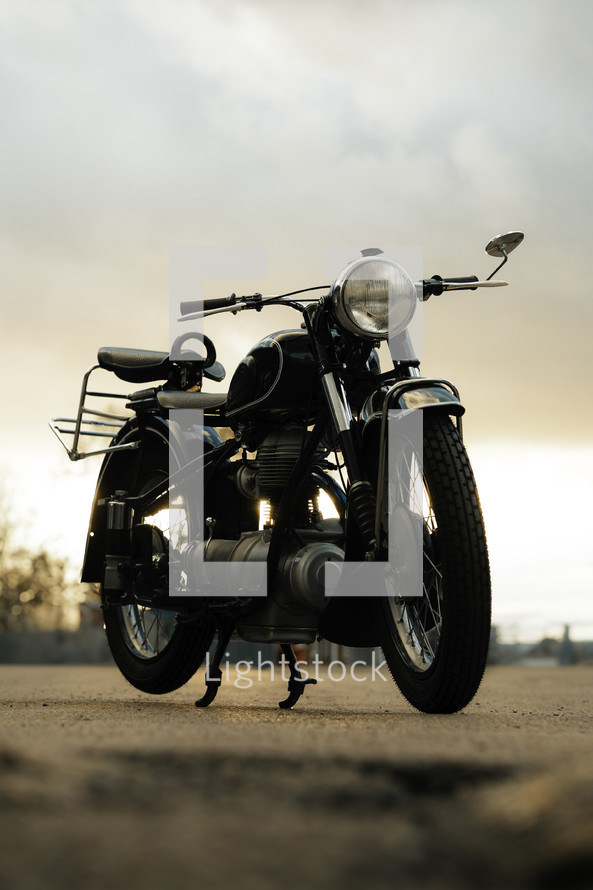 Vintage motorcycle, classic retro motorbike, black antique old bike at sunset