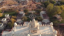 Jaswant Thada marble cenotaph standing above the cityscape of the blue city of Jodhpur, Rajasthan, India - Aerial Tilt up Reveal shot