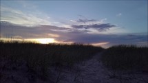 sand dunes on a beach at sunset 