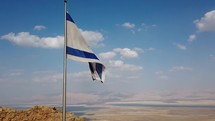 The Israel flag flying over the West Bank and the Dead Sea.