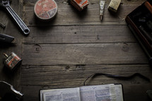 an open Bible surrounded by tools 