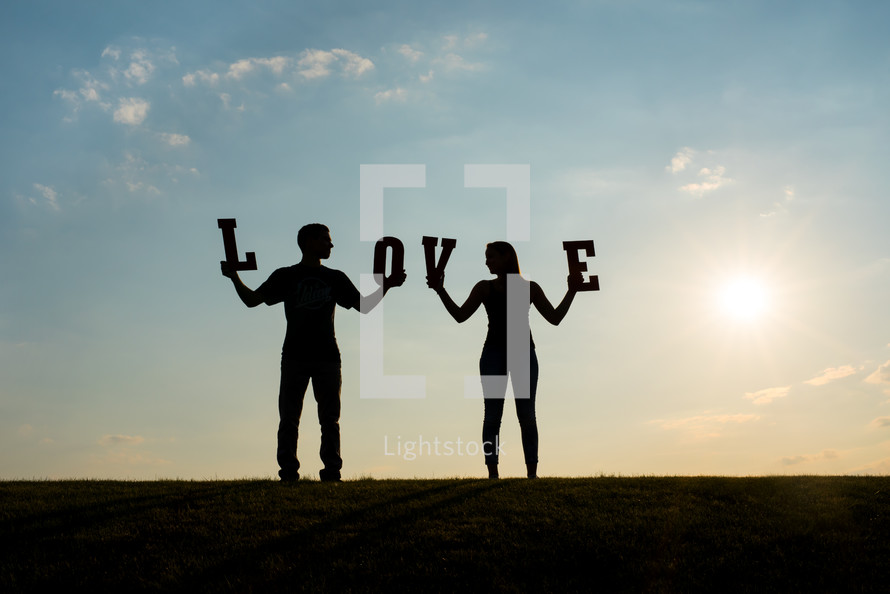 couple holding the word love 