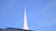 Subtle movement in a shot of a white steeple on a blue sky