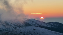 Colorful light of sunset evening over winter alpine mountains with clouds over snowy nature Time lapse
