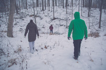 people walking through a forest in the winter 
