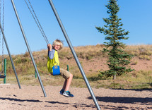 a boy child on a swing 