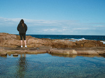 girl standing on a rocky shore in Nelson Bay 