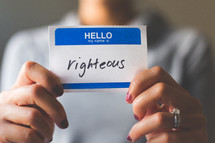 woman holding a name tag with the word righteous 