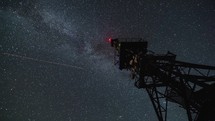 Milky way galaxy moving over communication tower in starry night Time lapse
