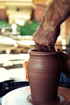 A potter puts the finishing touches on his clay pot