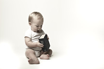 A baby plays with a Bible