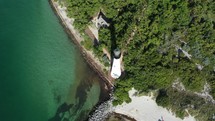 Cinematic aerial orbiting lighthouse on the sandy coastline