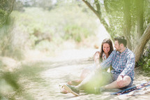 couple sitting under a tree together 