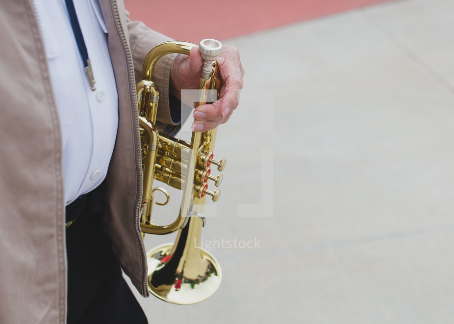 man walking carrying a trumpet 