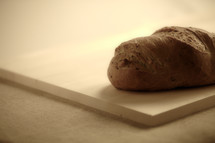 A loaf of bread sits on a cutting board.