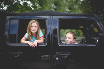 sisters looking out of Jeep windows 