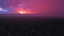 Aerial hazy view of a purple sunset after a storm with some light rain.