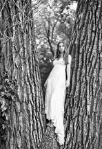 A woman in a white dress standing in a tree