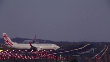 Planes on a runway at night.