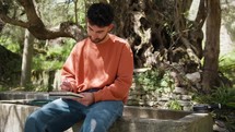 Philosopher Boy Thinks Seated Under The Olive Tree With Pencil And Notebook