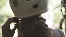 woman putting on a helmet 