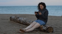 a woman reading a Bible on a beach 